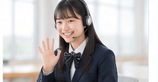 制服姿で手を振りながらオンラインレッスンを受ける女子学生