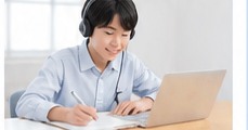 ヘッドセットを着けてノートパソコンで学習する男子学生