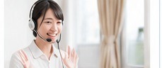 手を振りながら笑顔で挨拶するオンライン講師の女性